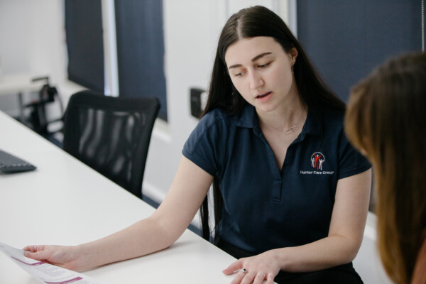 A Hunter Care Group team member discussing an NDIS plan with a participant.
